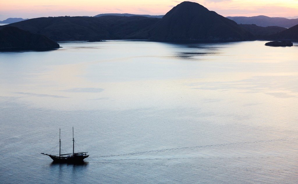 A phinisi sailing at dusk in Alor