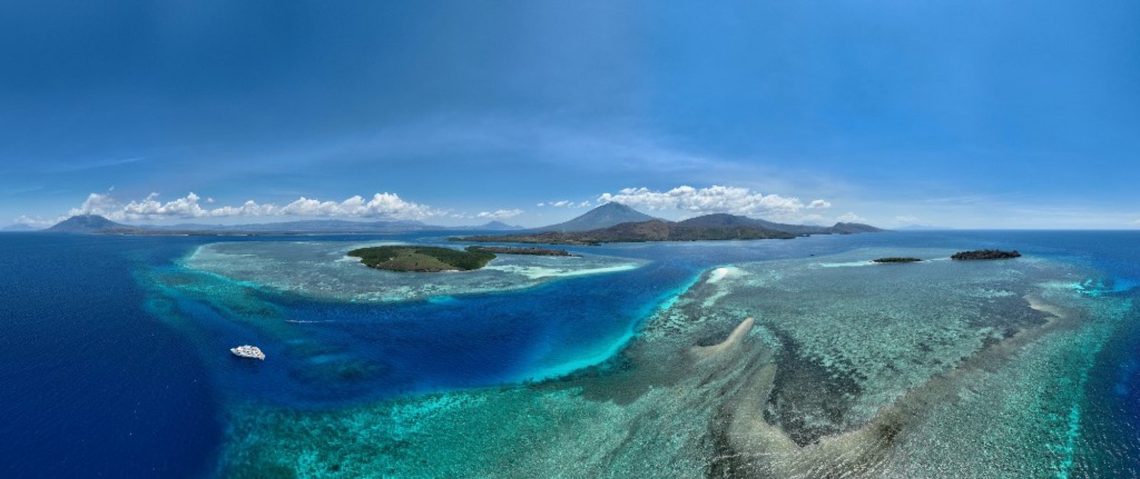 Aerial view of Alor reefs, islands, and a yacht in eastern Indonesia