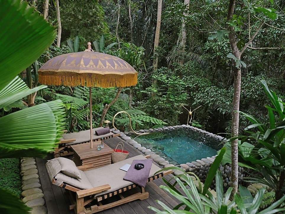 Loungers and a painted parasol beside a private plunge pool at Capella Ubud