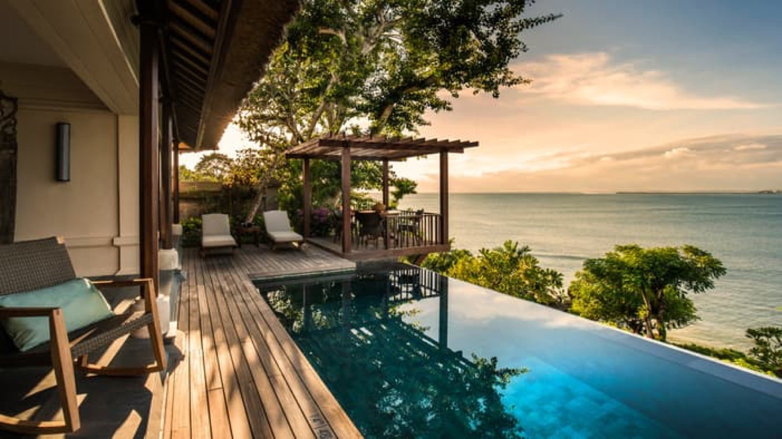 Villa infinity pool above the bay at sunset
