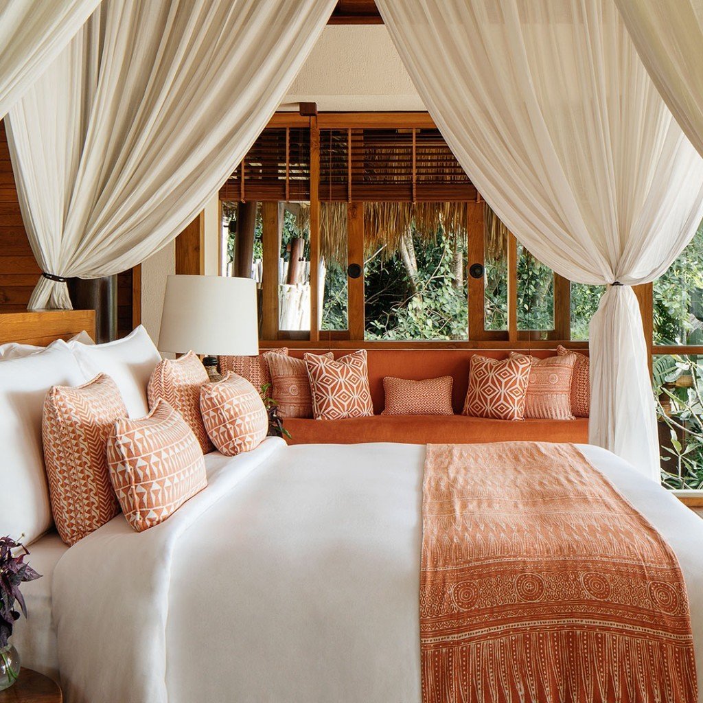 Canopy bed with Sumba textiles looking into the garden at Nihi Sumba