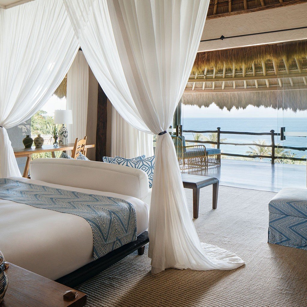 Canopy bed open to the ocean in a villa at Nihi Sumba