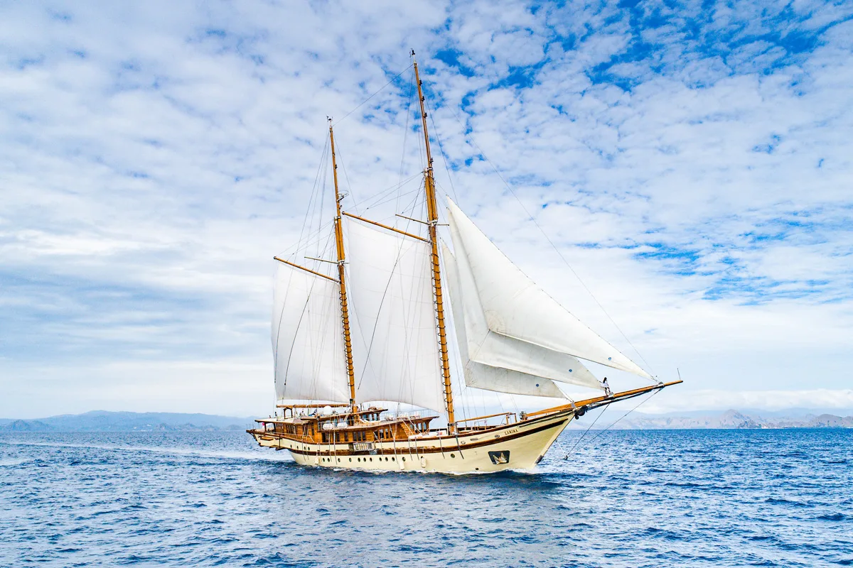 Lamima under full sail on deep blue water in Indonesia