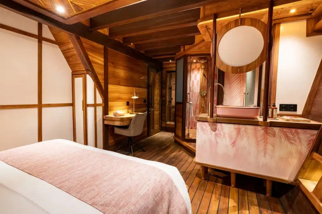 Blush deluxe suite on Otium, with the shower beyond the bed